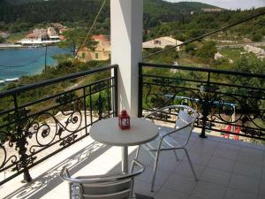 a table and chairs on a balcony with a view at Nicolas Rooms in Fiskardo