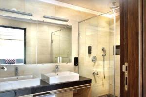 bagno con lavandino e doccia in vetro di Purple Cloud Hotel a Devanhalli
