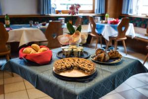 une table avec un tissu de table avec une tarte et du pain dans l'établissement B&B Cicolini, à Rabbi