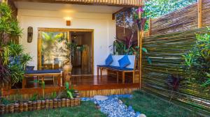 a patio with two blue chairs and a fence at Focus Rooms in El Nido