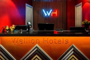 a lobby with a reception desk with a wilyn hotel sign at Wellion Vodniy in Moscow