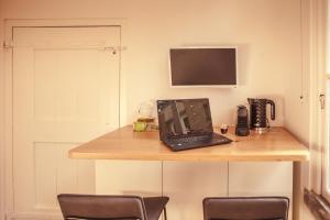 a laptop computer sitting on a wooden table with two chairs at Ververs slapen in Den Bosch
