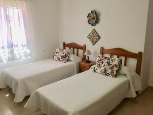 a bedroom with two beds and a window at Casa Victoria in Adeje