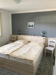 a large bed in a bedroom with two chairs at "Kombüse" by Ferienhaus Strandgut in Born +16 photos