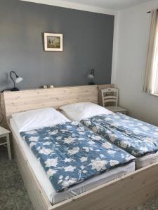 a bedroom with a bed with a blue and white blanket at "Kombüse" by Ferienhaus Strandgut in Born