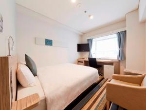 Schlafzimmer mit einem Bett, einem Schreibtisch und einem Stuhl in der Unterkunft Shinagawa Prince Hotel N Tower in Tokio