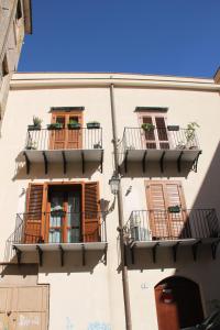 un edificio con balcones y ventanas en Cocciu d'amuri Holiday house, en Palermo