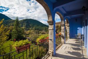 Casa azul con balcón con montañas al fondo en Casas Arana - Parque Nacional De Ordesa, en Albella
