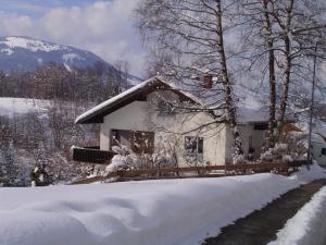 a house covered in snow in front of a mountain at Haus Kranzusch in Sonthofen