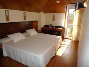 1 dormitorio con 1 cama blanca grande y escritorio en Doade en Hio