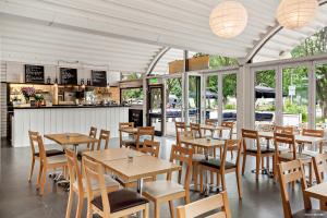 a restaurant with wooden tables and chairs and windows at First Camp Sibbarp-Malmö in Malmö