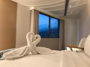 una camera d'albergo con due asciugamani cigni su un letto di Open Room Hotel a Tamsui