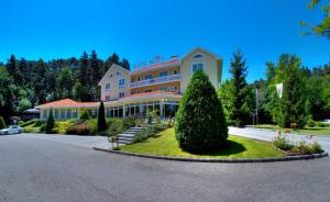 um edifício de hotel com um arbusto em frente em Villa Medici Hotel & Restaurant em Veszprém