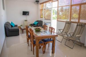 a living room with a wooden table and chairs at Bliss Apartment Hikkaduwa in Hikkaduwa