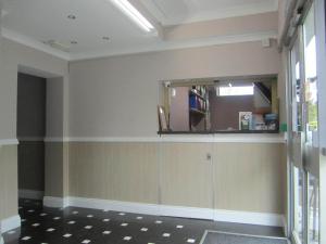 a room with a mirror, a sink, and a door at Lynden Court Hotel in Bournemouth