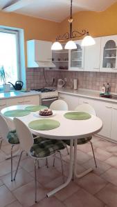 a white kitchen with a table and chairs in it at Apartmán Novákovi in Náchod