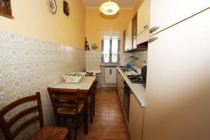 a kitchen with a table and chairs and a kitchen with a refrigerator at Casa Vacanze S.Angelo La Stella in Orvieto