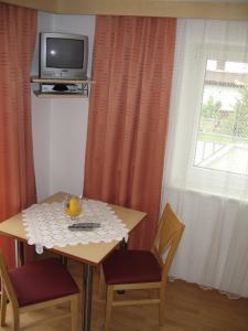 un tavolo con due sedie e una televisione su una finestra di Gästehaus Mrak a Längenfeld