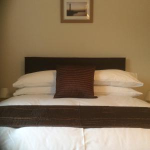 a bed with a brown pillow on top of it at Mill Croft Bed and Breakfast in Goathland