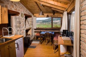 a kitchen and dining room with a table and a window at Stone house on the rock in Lílaia