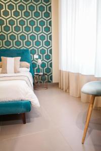 a bedroom with a bed and a blue chair at Palazzo Toledano in Naples