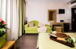 a living room with a green chair and a couch at Astir Notos in Potos