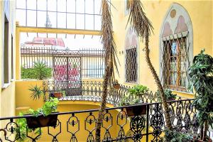 a yellow building with a balcony with plants at Appartamento Ernesto in Pistoia