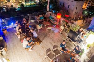 a group of people sitting at a bar at night at Marco Polo Party Hostel in St. Julianʼs
