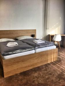 a bed with a wooden frame in a bedroom at Hotel Bothe in Považská Bystrica