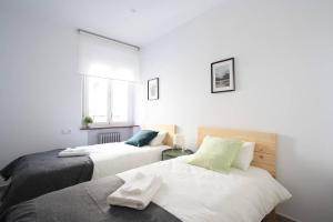 2 camas en una habitación con paredes blancas en Apartamento entero 4HB centro Salamanca by Batuecas, en Salamanca