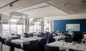 una sala de banquetes con mesas, sillas y paredes azules en Hotel Ampolla Sol en L'Ampolla