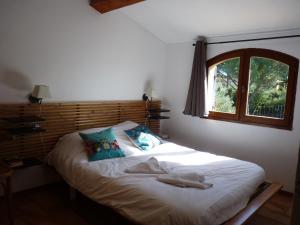 - un lit dans une chambre avec fenêtre dans l'établissement " le bosquet fruité en Provence Occitane, à Bagnols-sur-Cèze