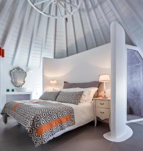 a white bedroom with a bed and a white ceiling at Absolute Mykonos Suites & More in Mýkonos City