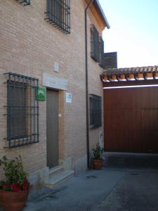 un edificio de ladrillo con una puerta y dos macetas en Casa Rural María Victoria, en Navas de Estena