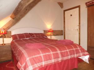 a bedroom with a red and white bed with two lamps at Lapwing Cottage in Stoke on Trent