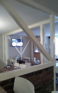 The Boathouse في Sutton Bridge: غرفة طعام مع طاولة وكراسي وتلفزيون