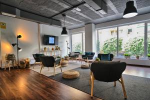 a living room with chairs and tables and windows at HQ Rooms Apartments San Vicente in Valencia