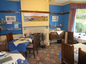 a dining room with blue walls and a fireplace at Brookfield B&B Guest House in Keswick