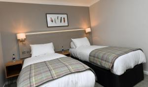 a hotel room with two beds and two lamps at Green Lodge, Wirral by Marston's Inns in Hoylake