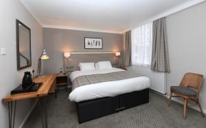 a hotel room with a bed and a desk at Green Lodge, Wirral by Marston's Inns in Hoylake
