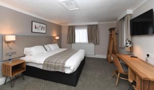 a hotel room with a bed and a desk at Green Lodge, Wirral by Marston's Inns in Hoylake