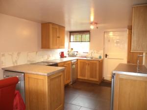 a kitchen with wooden cabinets and a counter top at Lapwing Cottage in Stoke on Trent