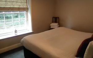 a bedroom with a white bed and a window at The Boathouse in Sutton Bridge
