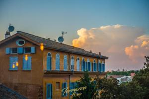 ローマにあるHotel Parrasioの青い窓と曇り空のある建物