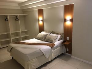 1 dormitorio con 1 cama con luces en la pared en Hotel Cantareira, en Niterói