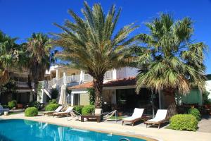 a resort with palm trees and a swimming pool at Sah Hotel in Bitez