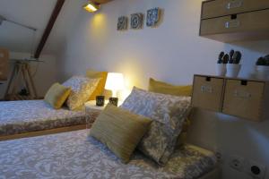 1 dormitorio con 2 camas y mesa con lámpara en Casa do Largo, en Alcácer do Sal