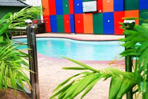 a swimming pool in front of a colorful building at Western Dreams Hotel in Abuja