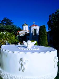 a white wedding cake with a church in the background at Villa St. Michael in Madara