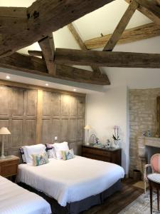 - 2 lits dans une chambre dotée de plafonds en bois dans l'établissement Hermitage St Roch, à Arc-en-Barrois